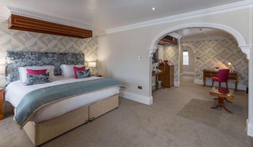 a bedroom with a king sized bed and a desk at Best Western Moores Central Hotel in St Peter Port