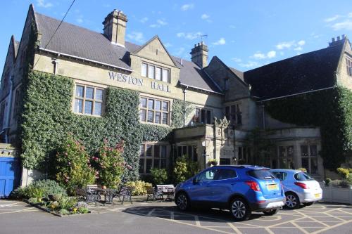a blue car parked in front of a building at Weston Hall Hotel Sure Hotel Collection by Best Western in Bulkington