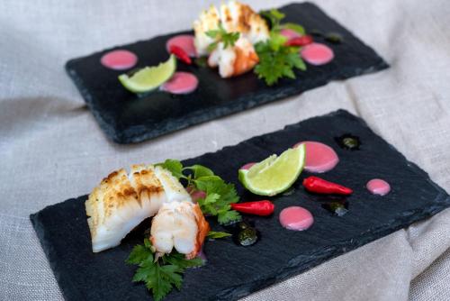 two black plates of food with sushi and vegetables at Tikitam Palms Boutique Hotel in Pongwe