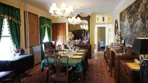 a dining room with a table and green curtains at A Night to Remember B & B in Niagara Falls