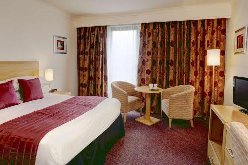 a hotel room with a bed and a table and a television at Best Western Frodsham Forest Hills Hotel in Frodsham