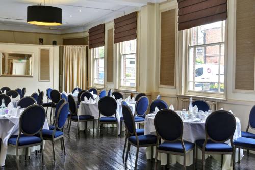 a dining room with tables and chairs and windows at The Rose & Crown Hotel, Sure Hotel Collection by Best Western in Tonbridge