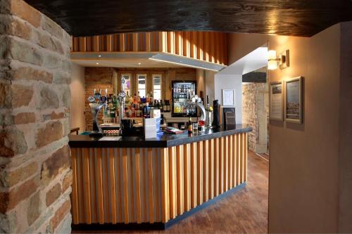 a bar in a restaurant with a brick wall at Best Western Plus Lancashire Manor Hotel in Skelmersdale