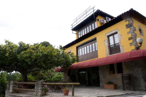 a yellow building with a table in front of it at El Foyu in Colunga