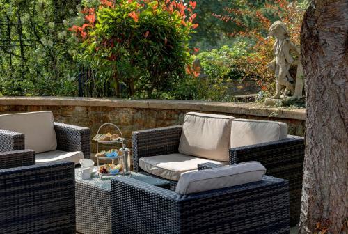 two wicker chairs and a table in a garden at Best Western Sysonby Knoll Hotel in Melton Mowbray