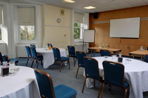 a conference room with tables and chairs and a whiteboard at Burn Hall Hotel in Huby