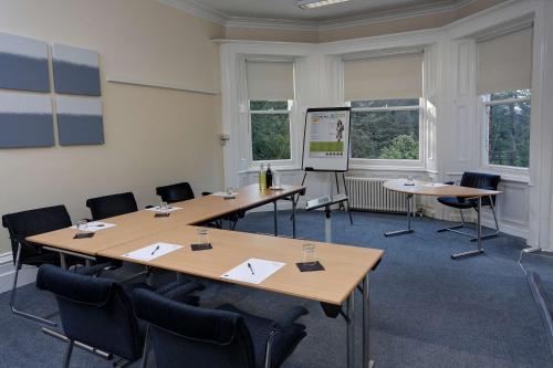 a meeting room with tables and chairs and a screen at Burn Hall Hotel in Huby