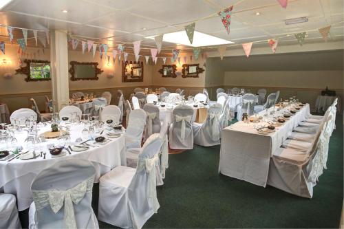 a banquet hall with white tables and chairs at The Grange at Oborne in Sherborne