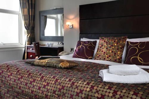 a bedroom with a large bed with a large headboard at Best Western Hotel Hatfield in Lowestoft