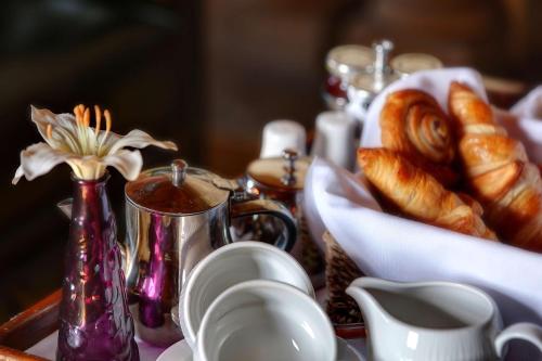 a table with a tray of pastries and a tray of croissants at Hazlewood Castle & Spa in Tadcaster