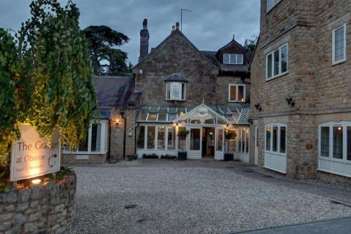 a large brick building with a sign in front of it at The Grange at Oborne in Sherborne
