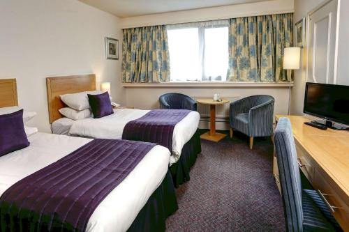 フロッドシャムにあるBest Western Frodsham Forest Hills Hotelのベッド2台、薄型テレビが備わるホテルルームです。