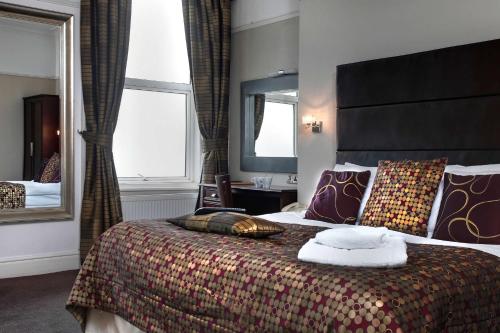 a hotel room with a bed and a large mirror at Best Western Hotel Hatfield in Lowestoft