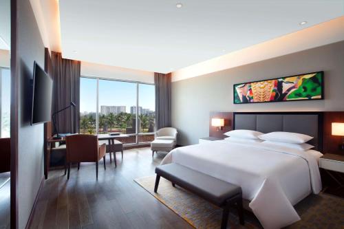 a hotel room with a large bed and a desk at Grand Hyatt Kochi Bolgatty in Cochin
