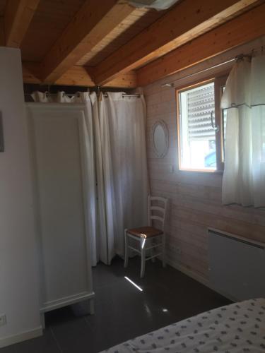 1 dormitorio con cama, ventana y silla en Villa Penfret - 50 meters from the beach en Île-Tudy