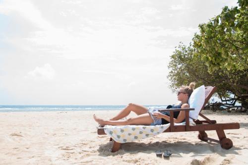 two people sitting in a chair on the beach at Liberty Guesthouse Maldives in Mahibadhoo