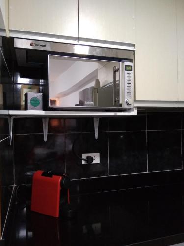 a microwave on a shelf in a kitchen at Lustra Studio in Davao City