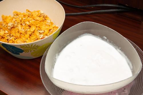 a bowl of milk next to a bowl of cereal at Kuretake Inn Gotemba Inter Gold Cabin in Gotemba