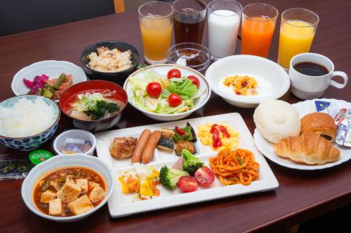 a table topped with plates of food and drinks at Kuretake Inn Gotemba Inter Gold Cabin in Gotemba