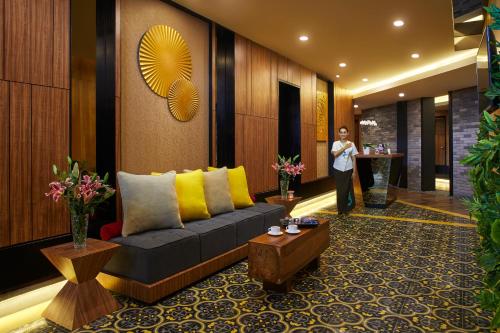 a man is standing in a lobby with a couch at Aston Sentul Lake Resort & Conference Center in Bogor
