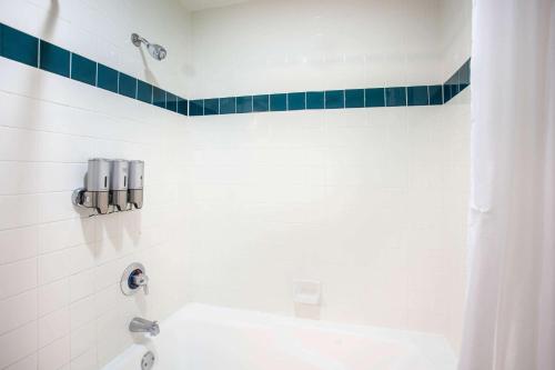 a white bathroom with a sink and a shower at Azure Hotel&Suites Ontario Trademark Collection by Wyndham in Ontario
