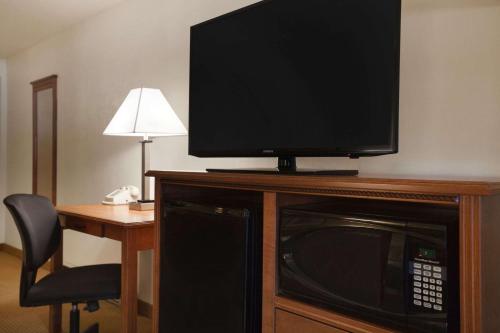 a flat screen tv sitting on top of a microwave at Super 8 by Wyndham Williston ND in Williston