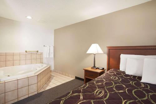 a hotel room with a bed and a bath tub at Super 8 by Wyndham Williston ND in Williston
