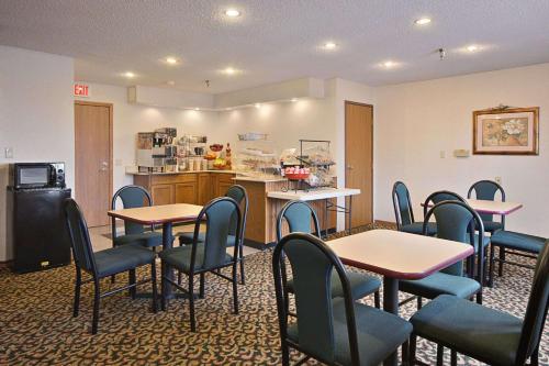 a waiting room with tables and chairs and a kitchen at Super 8 by Wyndham Crawfordsville in Crawfordsville