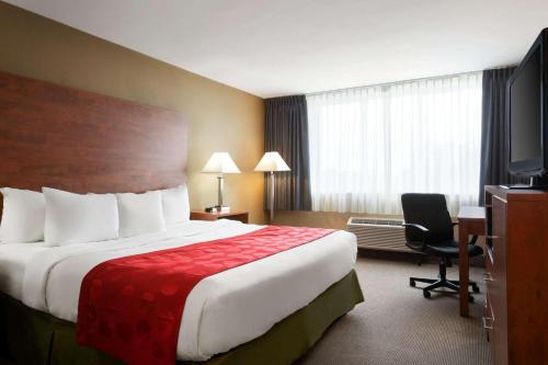 a hotel room with a large bed and a television at Ramada Plaza by Wyndham Montreal in Montréal