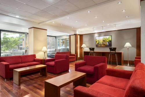 a waiting room with red chairs and a table at Ramada Plaza by Wyndham Montreal in Montréal