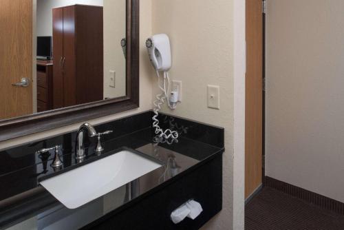 a bathroom with a sink and a phone on the wall at AmericInn by Wyndham Belle Fourche in Belle Fourche