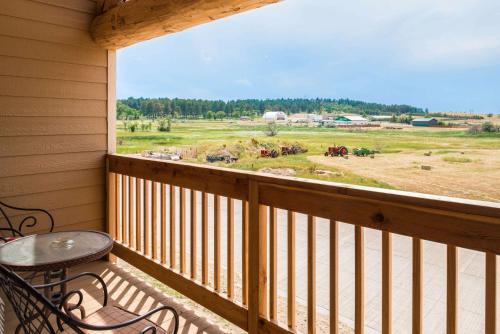 a balcony with a table and a view of a field at AmericInn by Wyndham Belle Fourche in Belle Fourche