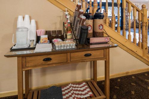 a wooden table next to a staircase with bottles on it at AmericInn by Wyndham Belle Fourche in Belle Fourche
