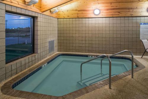 a hot tub in a room with a tiled wall at AmericInn by Wyndham Belle Fourche in Belle Fourche