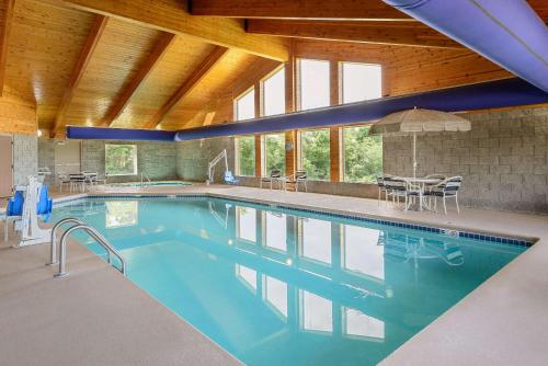 a large swimming pool with blue water in a building at AmericInn by Wyndham Republic in Republic