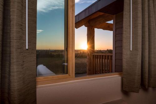 a window with a view of the sunset at AmericInn by Wyndham Belle Fourche in Belle Fourche