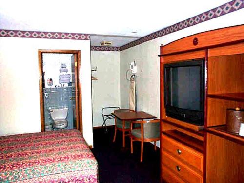 a hotel room with a bed and a television at Wesley Inn & Suites in Middletown