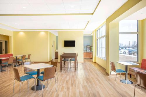 a waiting room with tables and chairs and windows at Days Inn & Suites by Wyndham Kearney NE in Kearney