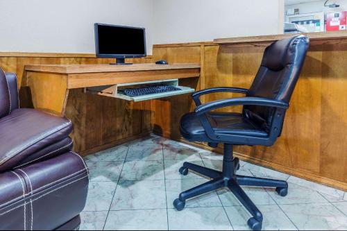 a desk with a computer monitor and a chair at Super 8 by Wyndham Irving DFW Airport/South in Irving
