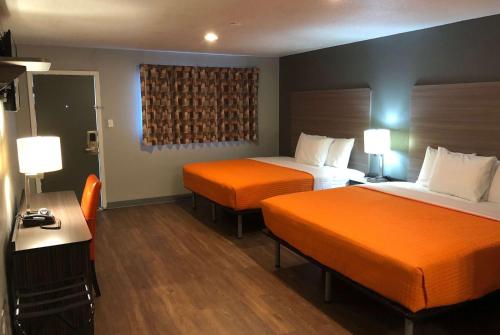 Habitación de hotel con 2 camas con sábanas de color naranja en Super 8 by Wyndham Sonora, en Sonora