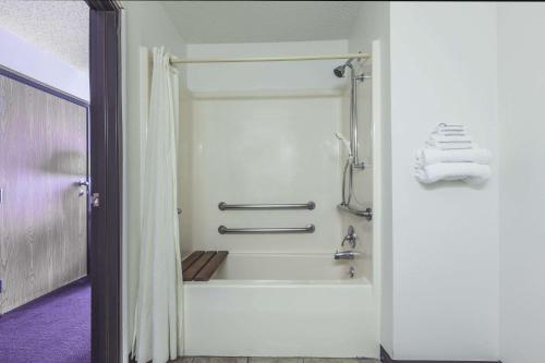 a bathroom with a shower and a bath tub at Super 8 by Wyndham Irving DFW Airport/South in Irving