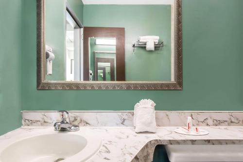 y baño con lavabo y espejo. en Super 8 by Wyndham St. Augustine, en St. Augustine