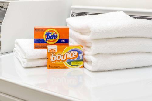 a pile of towels and a box of cleaner on a counter at Super 8 by Wyndham Burleson Fort Worth Area in Burleson