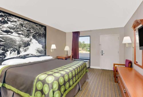 a hotel room with a bed and a large window at Super 8 by Wyndham Athens in Athens