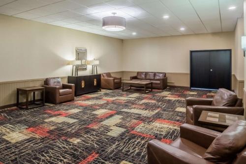 a waiting room with leather chairs and a flat screen tv at Ramada by Wyndham Grand Forks in Grand Forks