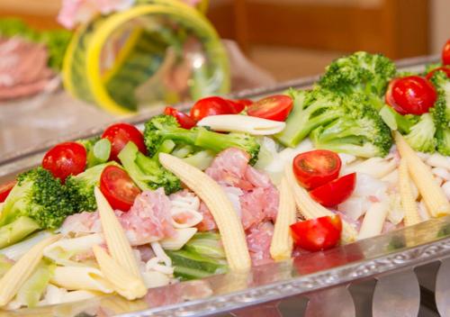 a tray of pasta with broccoli tomatoes and meat at Uomisaki Hotel in Atami