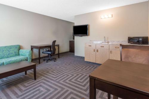 a hotel room with a couch chair and a table at Super 8 by Wyndham LaGrande in La Grande