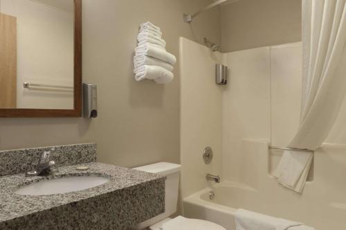 y baño con lavabo, aseo y ducha. en Super 8 by Wyndham Bridgeview/Chicago Area, en Bridgeview