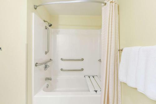 a bathroom with a shower and a white tub at Super 8 by Wyndham Burleson Fort Worth Area in Burleson