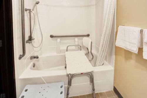 Heath的住宿－希思速8酒店，带浴缸的浴室和椅子。